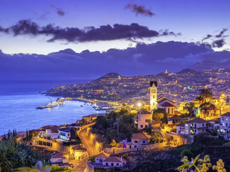 Erleben Sie magische Sonnenuntergänge auf Madeira: wo Stadtlichter und Atlantik verschmelzen.