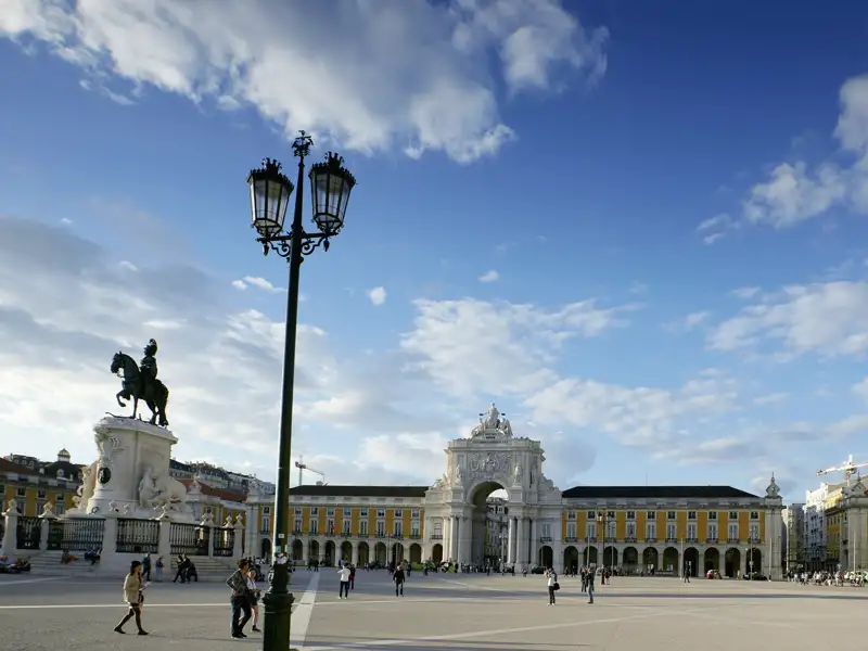 Historischer Praça do Comércio in Lissabon mit Reiterstandbild und dem Triumphbogen Arco da Rua Augusta bei Sonnenschein.