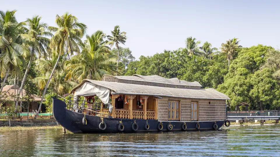 Traditionelles Hausboot steht am Ufer in den Backwaters von Kerala.