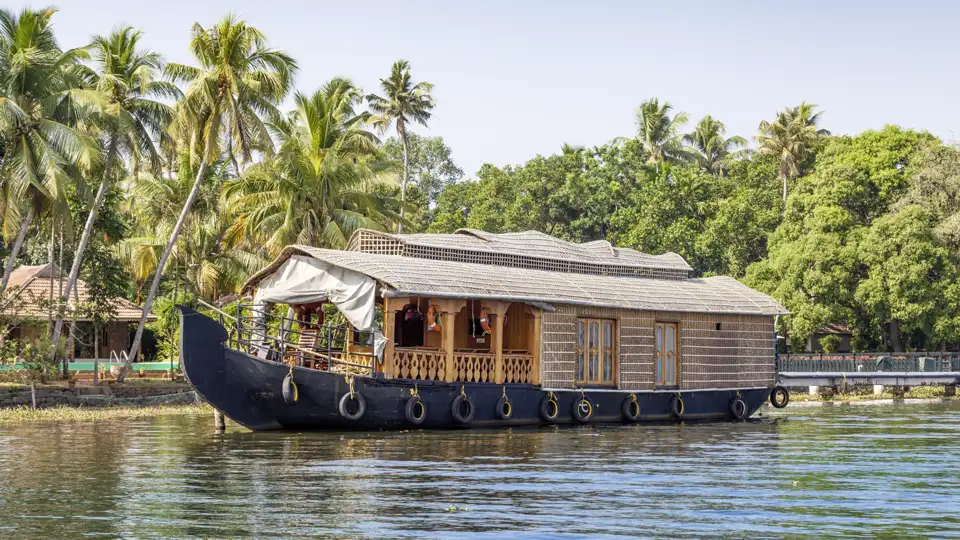 Traditionelles Hausboot steht am Ufer in den Backwaters von Kerala.